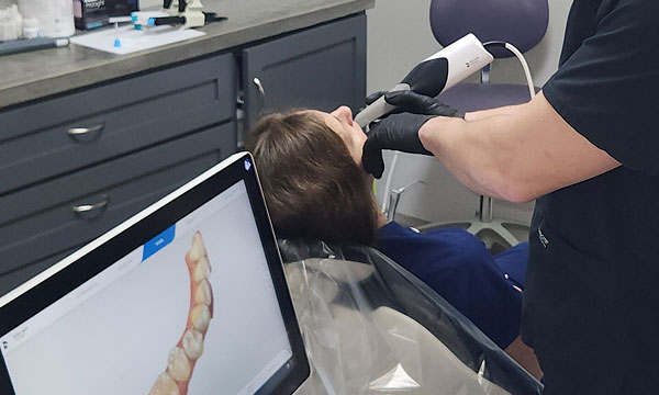dentist using 3d scanner on patient's teeth